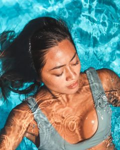 Woman swimming at the pool with eyelash extensions